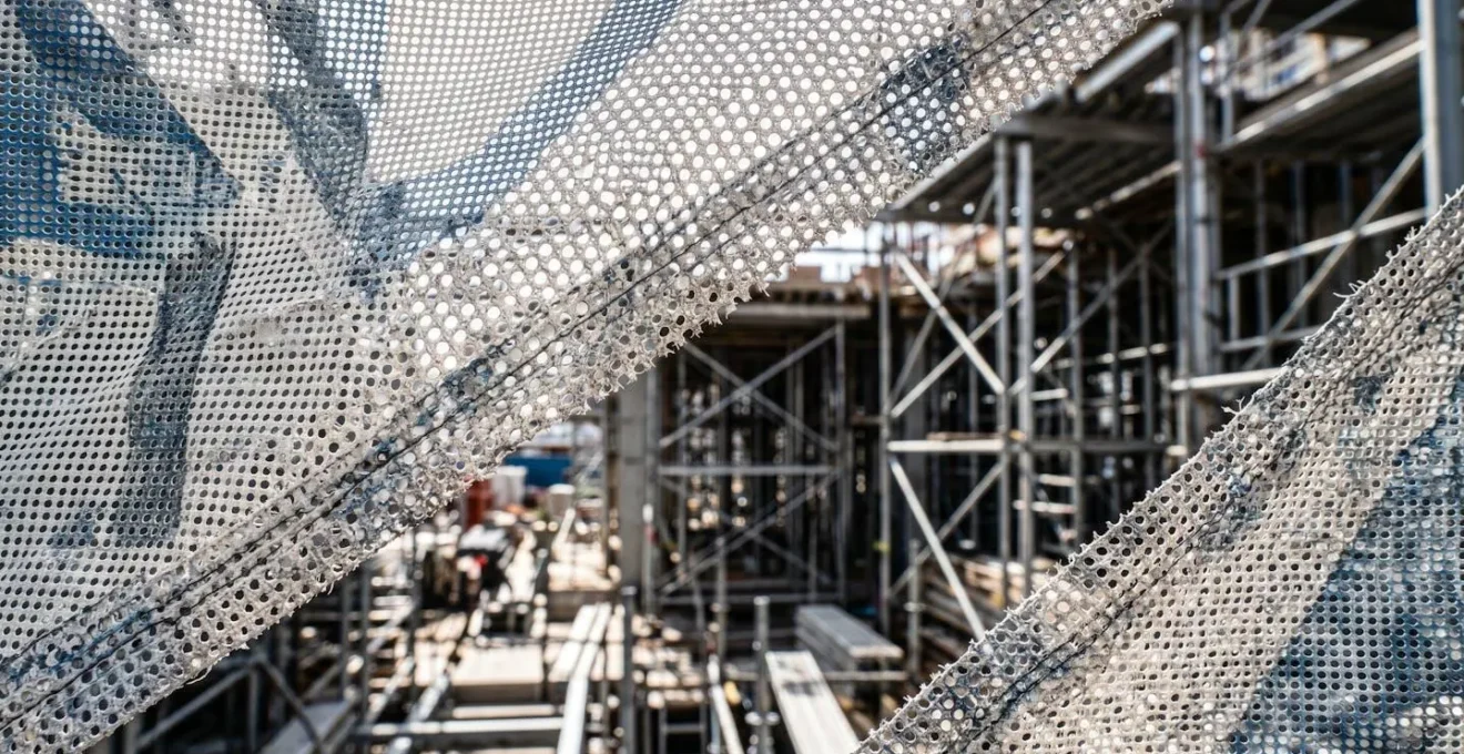 Vue détaillée d'une bâche mesh installée sur échafaudage montrant la micro-perforation
